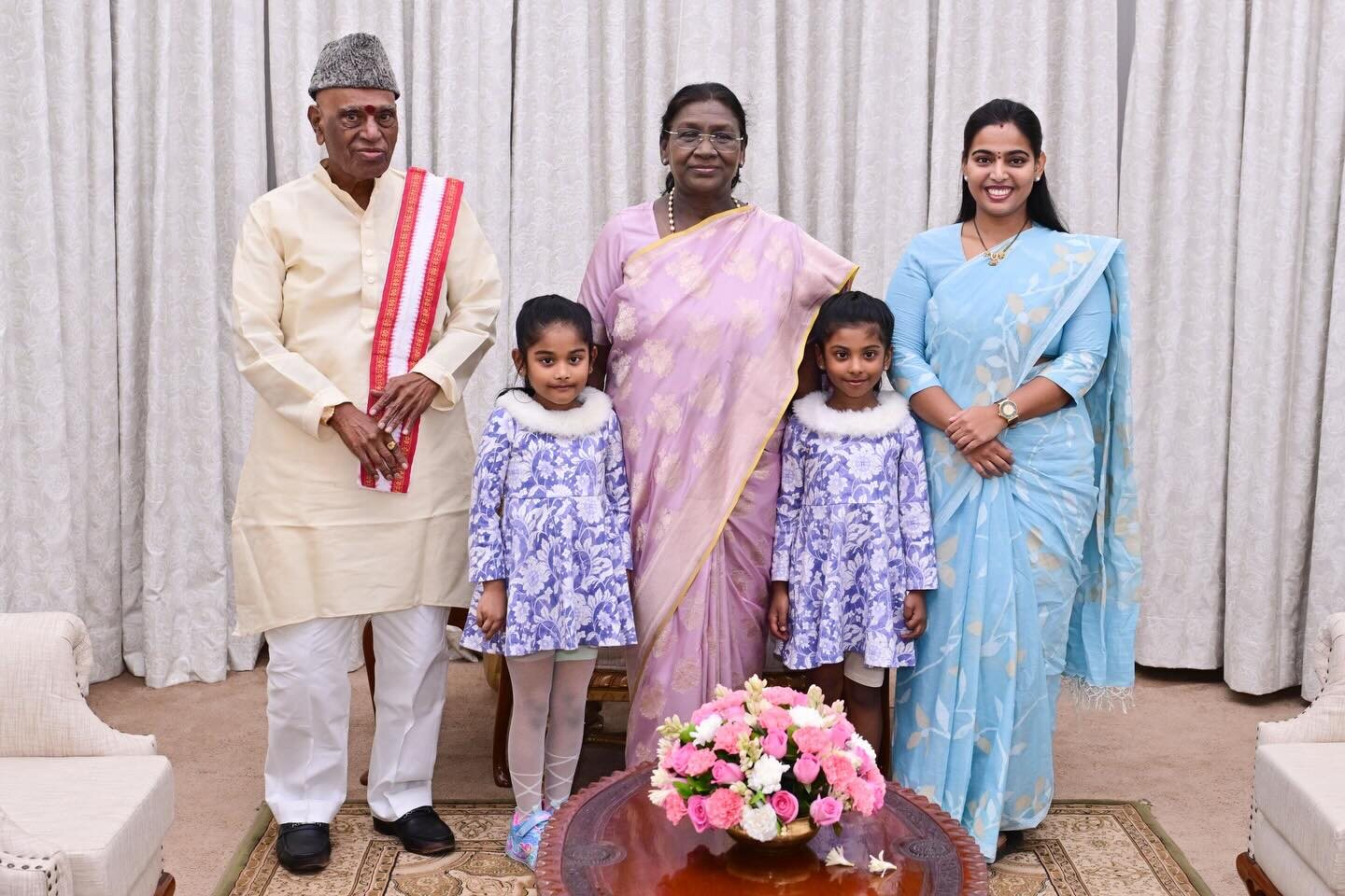 President Droupadi Murmu with a family, including two children, at an official reception